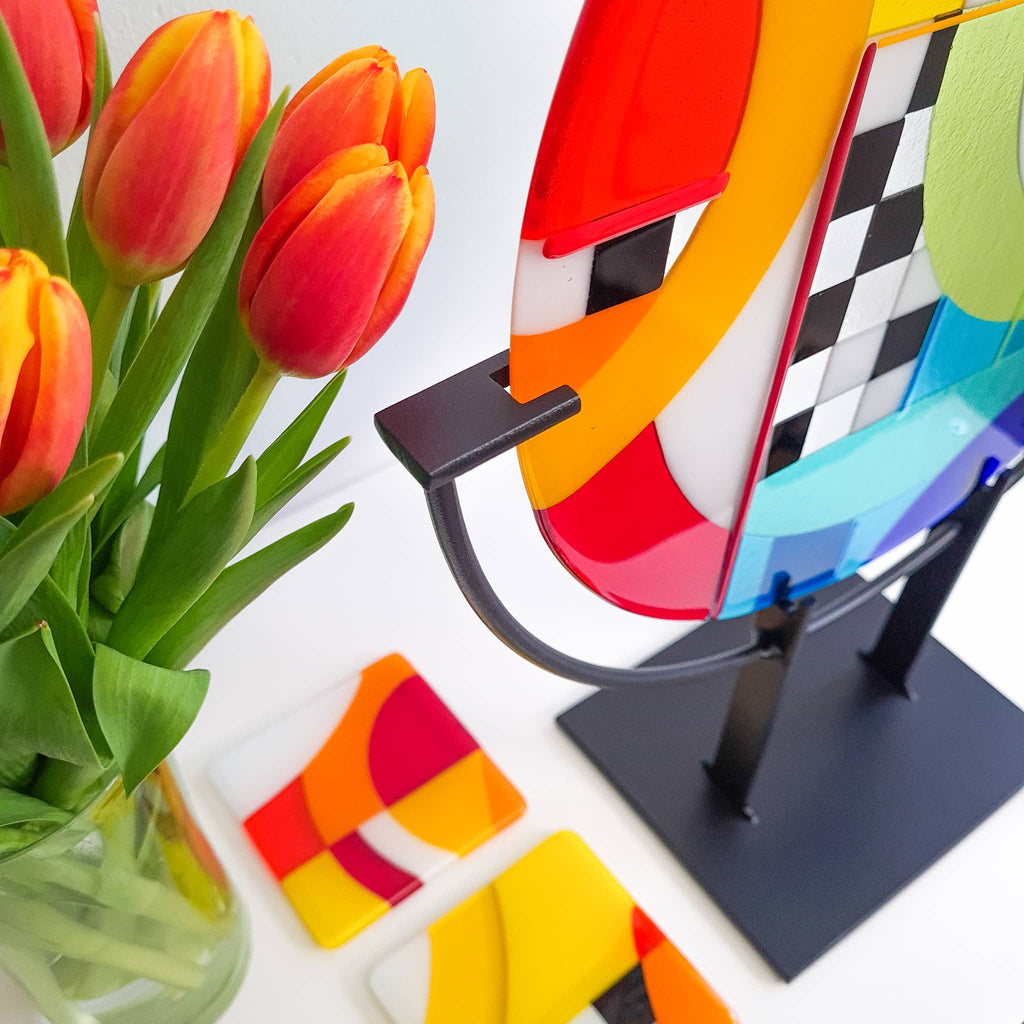 Chequer glass art roundel on display stand with tulips