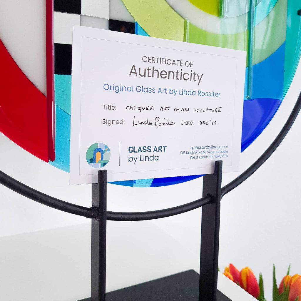 Certificate of Authenticity for Chequer medium round fused glass art sculpture by Glass Art by Linda. Fused glass roundel in rainbow colours in a Hard Edge glass art style